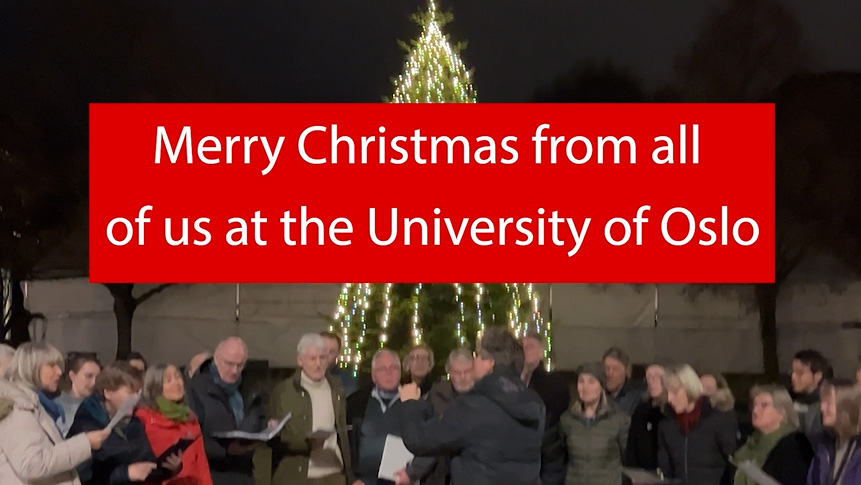 Red poster that says "Merry Christmas from all of us at the University of Oslo" with a choir and Christmas tree in the backgroun