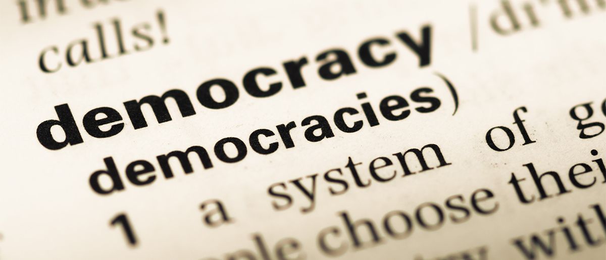 A close up of a page in a dictionary with the word "democracy". Photo.