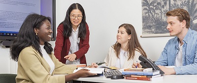 Four students discussing at a table