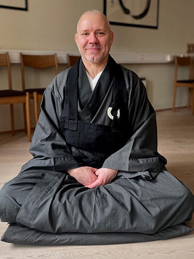 Portrait of Buddhist conversation partner Shind sitting on the floor
