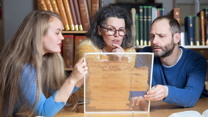 Researchers at the University of Oslo examining an old manuscript
