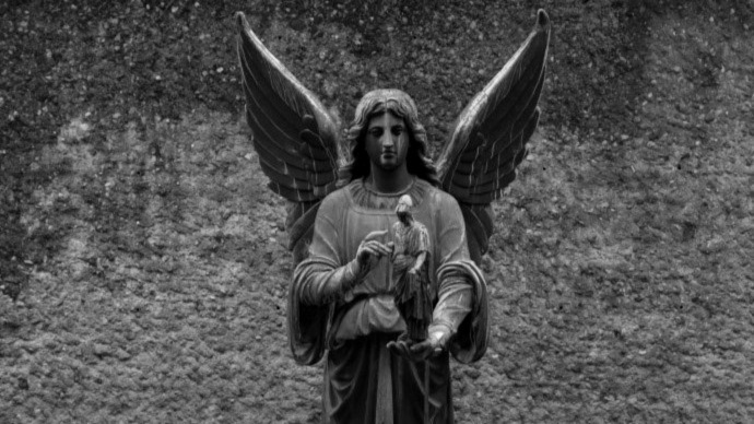 En statue av en engel som holder en liten figur av Athene i h?nden.  