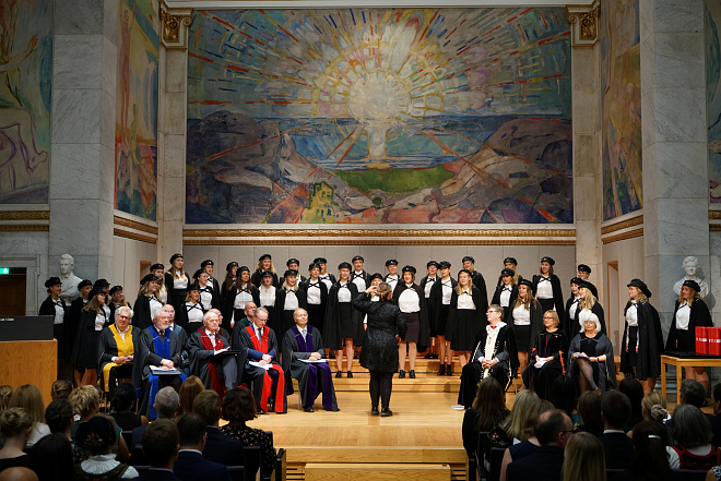 Universitetsledelsen, dekaner og kor p? scenen i aulaen. Foto: Terje Heiestad/UiO