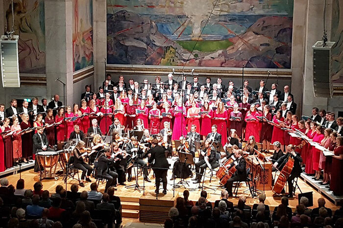 Choir photo of the University of Oslo's male and female choirs performing in the University Aula