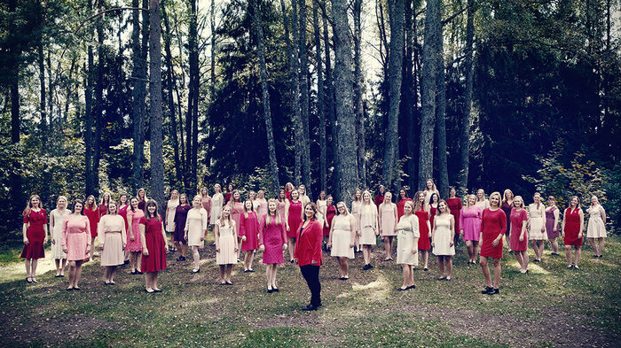 Bilde av alle kormedlemer i Kvindelige Studenters Sangforening med tr?r i bakgrunnen