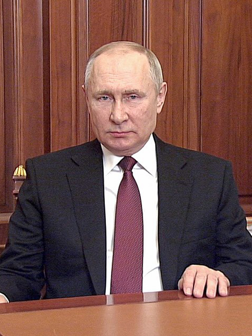 Vladimir Putin ved skrivebordet. Alvorlig eldre mann i dress.