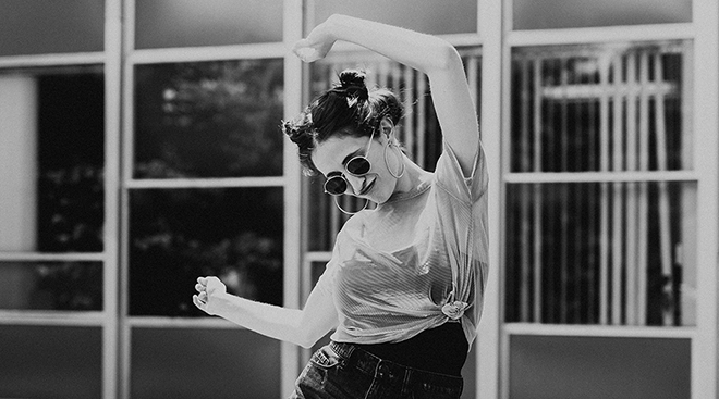 Black and white photo of girl with sunglasses dancing
