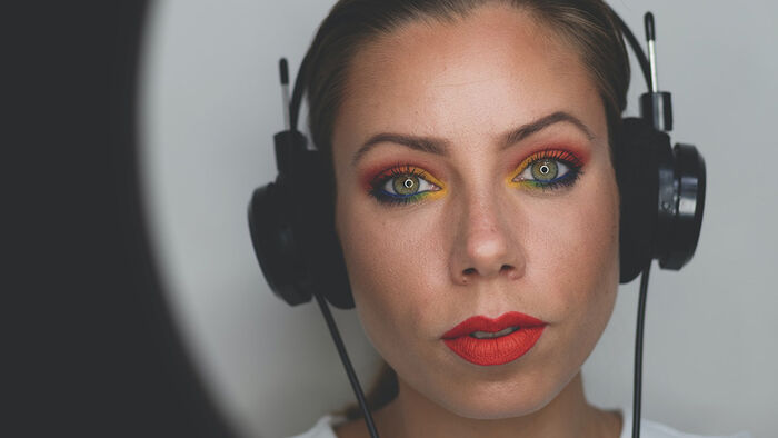 A photo of a woman with green eyes wearing a headset.