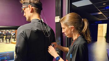 Laura Bishop checks that both the eye-tracking glasses and motion capture suit are ready to be tested by conductor ?yvind Bjor?.