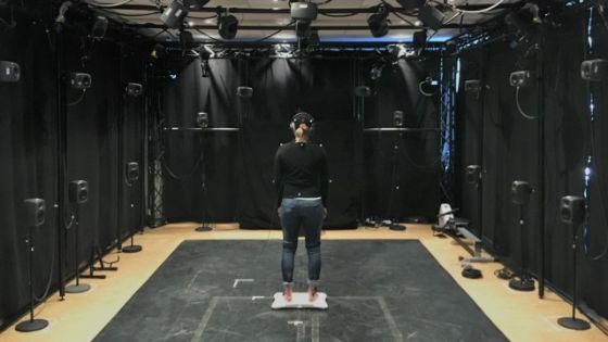 Woman standing in the motion capture lab. She is facing away from the camera.