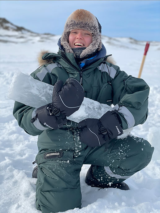 Portrett av studenten Celine p? Svalbard i vinterdress og med isblokk i h?nda