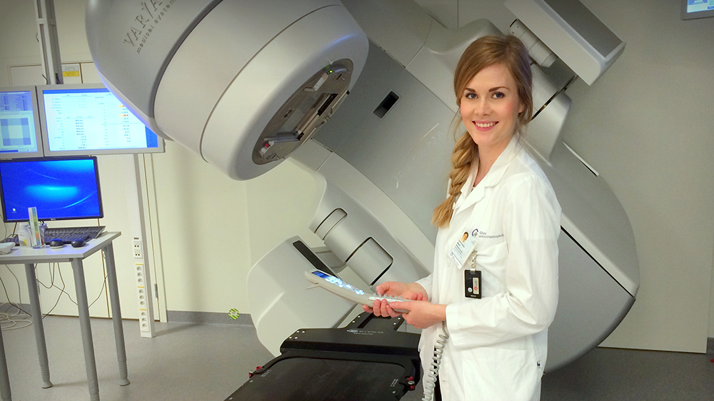 Kvinnelig fysiker foran en CT-scanner p? sykehus