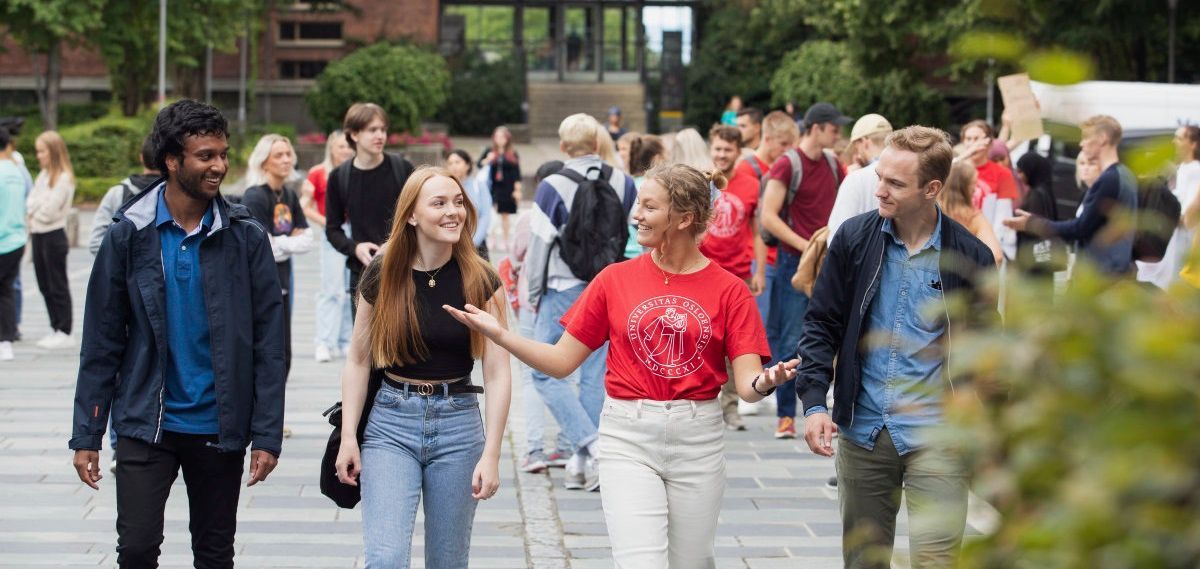 Three students walking towards the camera on campus. Photo.
